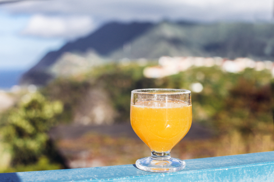 Ein Glas mit dem berühmten Poncha von Madeira steht auf einem Geländer